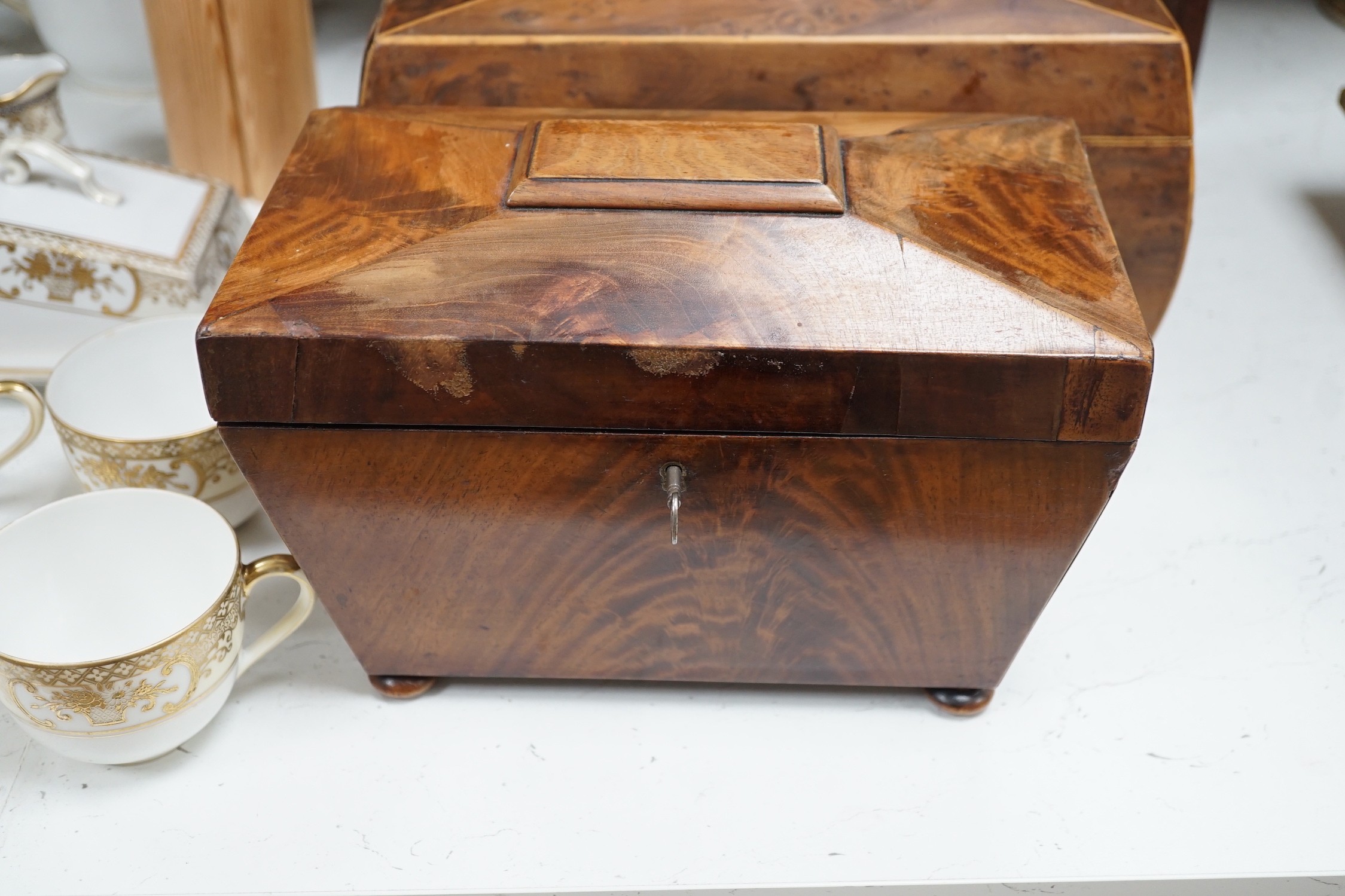 A Victorian boxwood strung burr yew sarcophagus shaped tea caddy, another mahogany tea caddy, a brass bound mahogany silver box with Bramah lock and another mahogany box. Largest 40cm wide